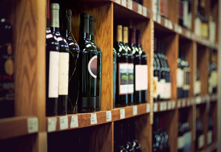 Wine bottles on wooden shelf in wine store
